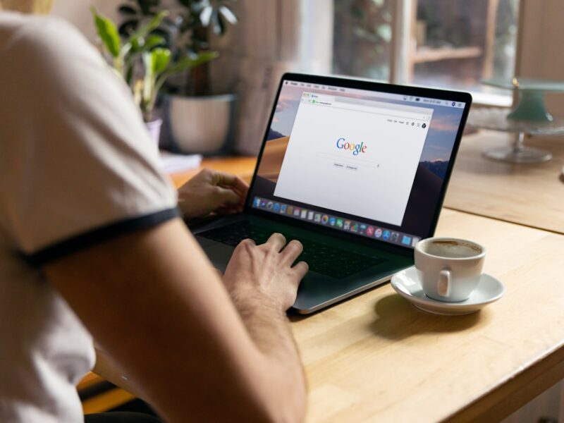 Iemand zoekt op een laptop met de Google-zoekpagina open